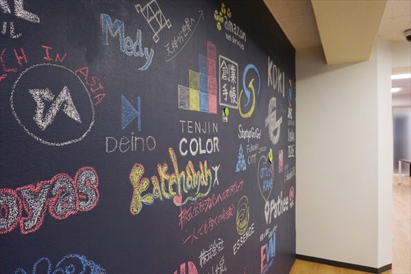 壁一面の黒板には、協力企業などのロゴマークがぎっしり